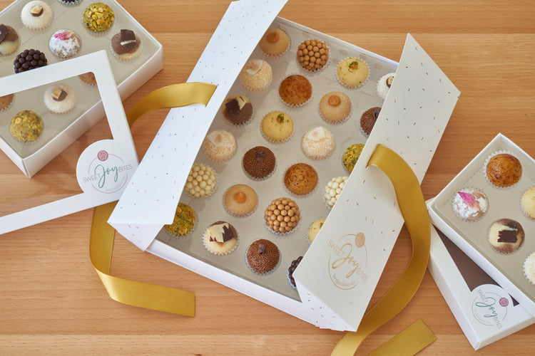 Sweet Joy Bites gift boxes of assorted brigadeiros with gold ribbon